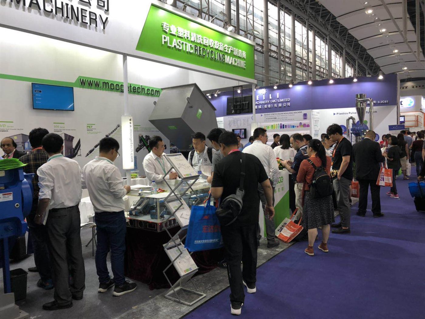 Visitors exploring MOOGE recycling equipment at the booth