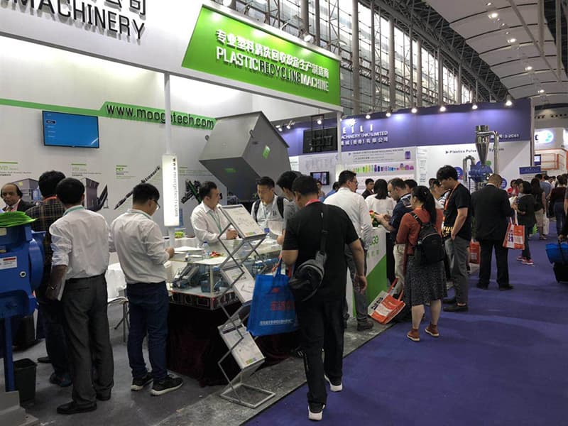 Visitors exploring MOOGE recycling equipment at the booth
